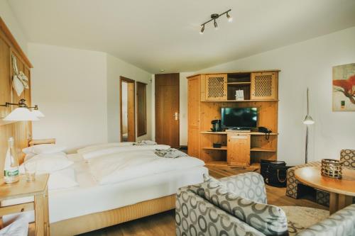 a bedroom with a large bed and a living room at Hotel Lauterbad in Freudenstadt