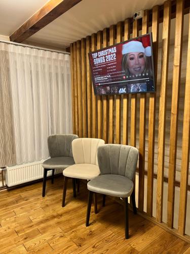 una sala d'attesa con tre sedie e un televisore di Байка Карпат a Vorokhta