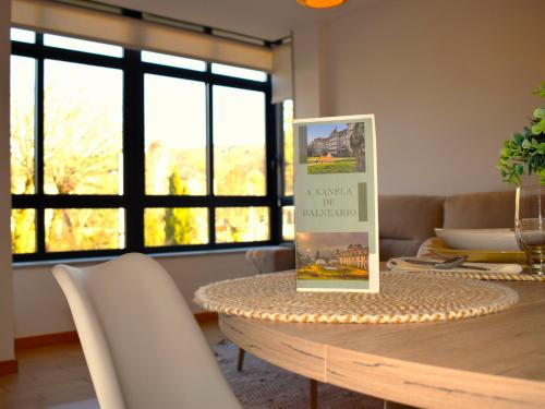 a dining room table with a picture on top of it at A Xanela de Balneario in Mondariz-Balneario