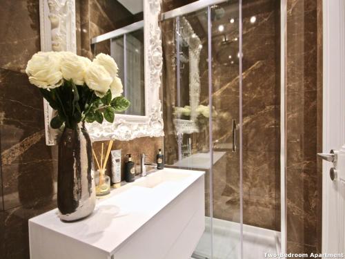 W łazience znajduje się waza z białymi różami. w obiekcie Akicity Amoreiras Light w Lizbonie
