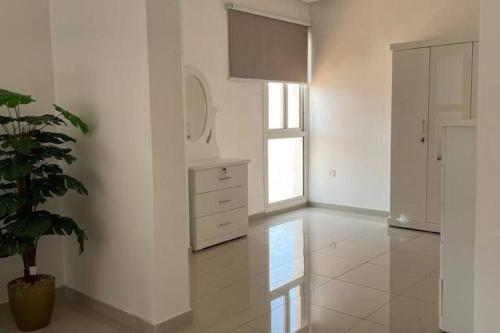 Habitación blanca con maceta y cómoda en Villa near Sunset Beach, en Al Khobar
