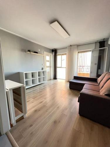 uma sala de estar com um sofá e um piso de madeira em La morada de Crevillent em Crevillente