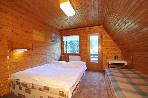 a bedroom with a bed in a wooden cabin at Chata Repiská in Demanovska Dolina