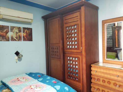 a bedroom with a wooden cabinet and a bed at Stanley Bridge Apartment in Alexandria
