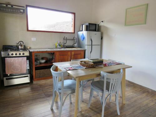 a kitchen with a wooden table and a refrigerator at La Nochera in Tilcara