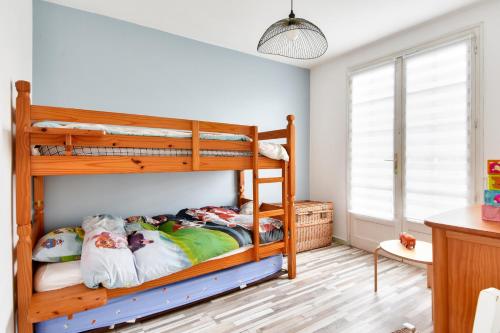a bedroom with two bunk beds in a room at Entre plage et marais salants, maison pour 6 in Les Bussolleries