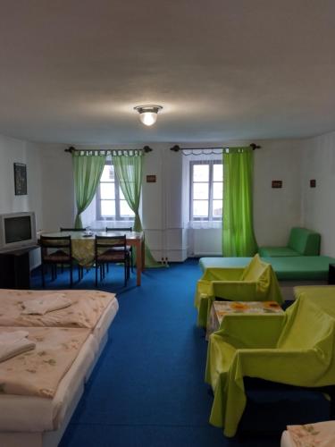 a room with several beds and a table and chairs at Hotel Parkán in Prachatice