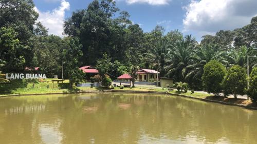 a pond in front of a building in a park at Lang Buana Eco Park in Jerantut