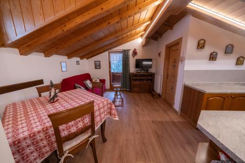 a kitchen and a dining room with a table in a room at Appartamenti Kratter Pietro in Sappada