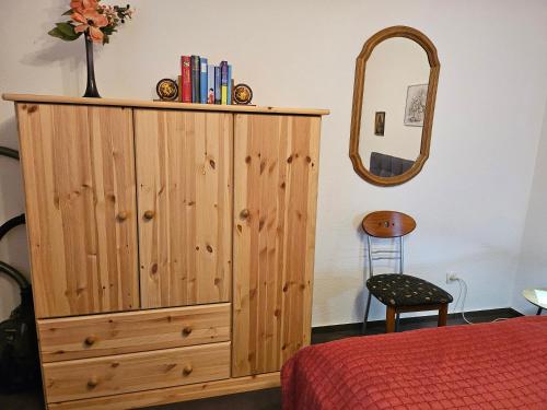 Petersdorf auf FehmarnにあるAppartement Kanewのベッドルーム(木製キャビネット、鏡付)