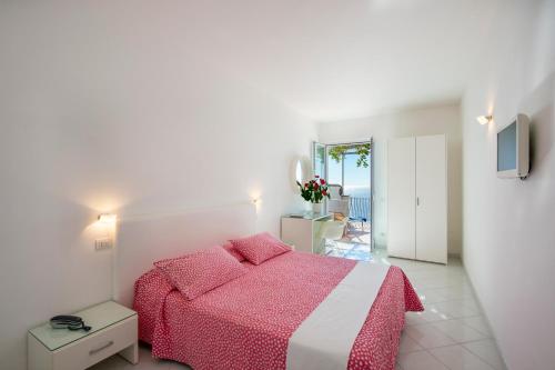 a bedroom with a bed with a pink blanket at Il Barilotto in Positano