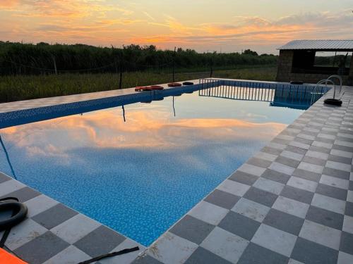 a swimming pool with a reflection of the sky at Greenlife farm resort in Sasan Gir