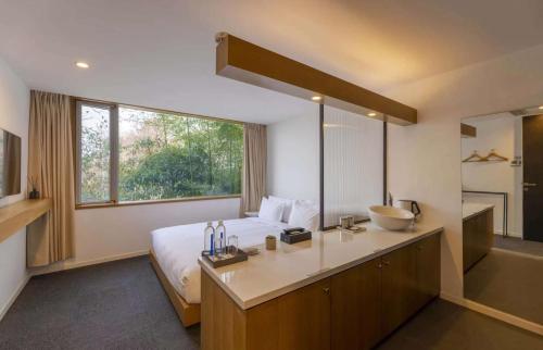 a bedroom with a bed and a sink and a bathroom at Aventree Hotel in Hangzhou