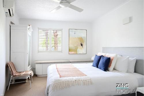 ヌーサヘッズにあるSt Tropez 10 - Relaxing Noosa Water Views & Poolの白いベッドルーム(大型ベッド1台、天井ファン付)