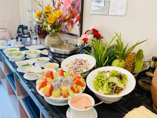 a buffet with bowls of food on a table at Hera Luxury Hotel in Ho Chi Minh City