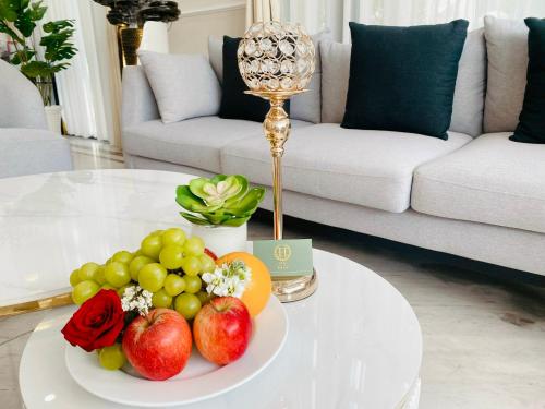 a white coffee table with a plate of fruit on it at Hera Luxury Hotel in Ho Chi Minh City