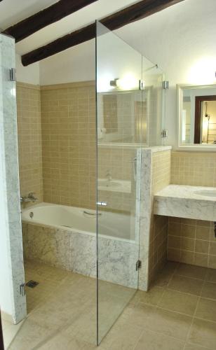 a bathroom with a shower and a tub and a sink at PETIT HOTEL ALGAIDA in Algaida