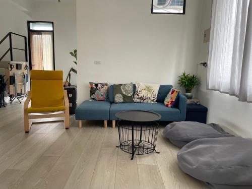 a living room with a blue couch and a table at Tino House 全新開幕 質感包棟民宿 in Yilan City