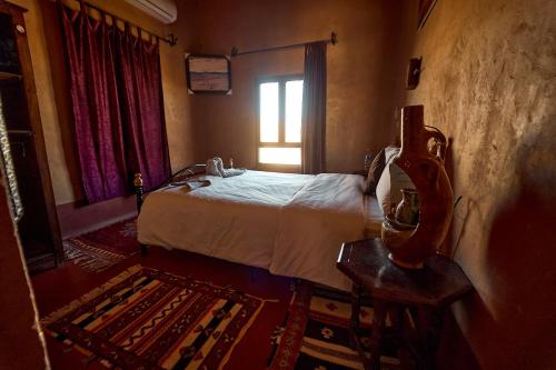 a hotel room with a bed and a window at Chez Brahim vue panoramique in Aït Ben Haddou