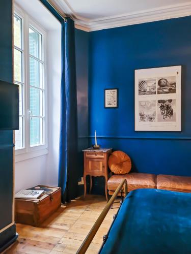 a blue room with a couch and a table at Domaine Le Clos de la Source - Spa - Petit déjeuner buffet - Atelier d'art in Montrichard