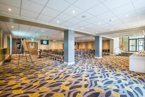 a banquet hall with chairs and a stage in a building at Holiday Inn Lancaster by IHG in Lancaster