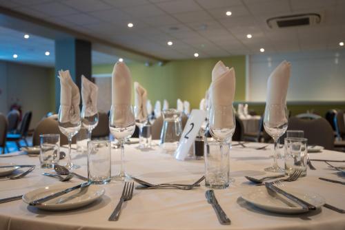 a long table with glasses and napkins on it at Holiday Inn Lancaster by IHG in Lancaster