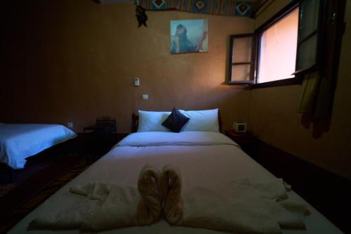 a bedroom with two beds and a window at Chez Brahim vue panoramique in Aït Ben Haddou