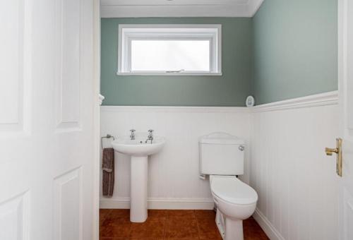 a bathroom with a toilet and a sink at Historical and Quirky Home in Braintree