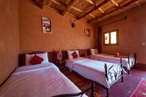 1 dormitorio con 3 camas en una habitación en Chez Brahim vue panoramique, en Aït Ben Haddou