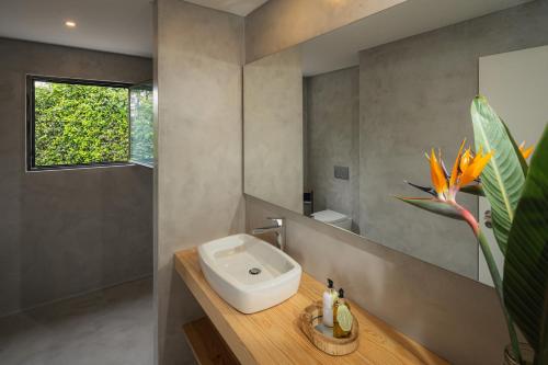 een badkamer met een witte wastafel en een raam bij Carmo Country Villas in Ponta Delgada