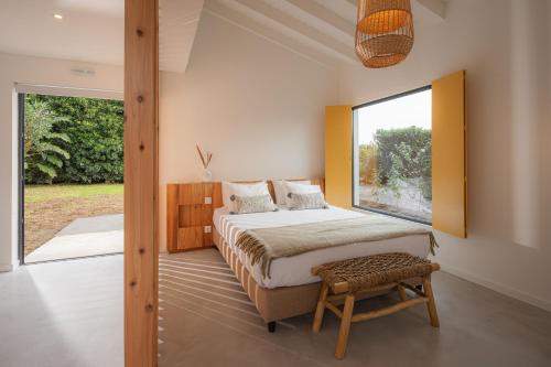 a bedroom with a bed and a large window at Carmo Country Villas in Ponta Delgada