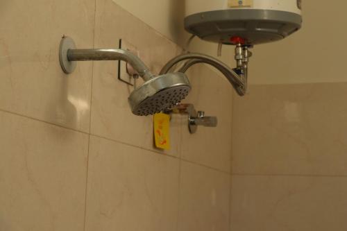 a shower head on a wall in a bathroom at Yoga Vairagyam Tapovan in Rishīkesh