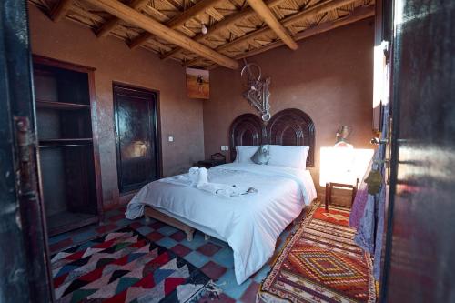 1 dormitorio con 1 cama grande y toallas. en Chez Brahim vue panoramique, en Aït Ben Haddou
