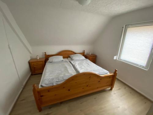 una camera con letto in legno e finestra di NEU! Ferienhaus Helena a Oberthal