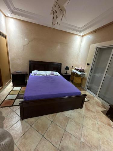 a bedroom with a bed with a purple blanket at Holikeys - El jadida - 2 Ch - Sidi Bouzid 001 in El Jadida