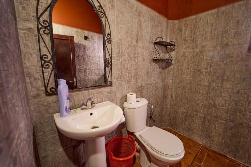 a bathroom with a sink and a toilet and a mirror at Chez Brahim vue panoramique in Aït Ben Haddou