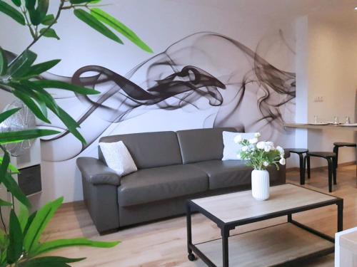 una sala de estar con sofá y una pintura en la pared en Vue Montagne - Appt Cosy et calme - Netflix - Fibre en Grenoble