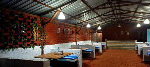 ein Esszimmer mit Tischen und Stühlen und einer Ziegelwand in der Unterkunft Mysticstays Resort in Wai
