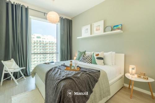 a bedroom with a bed and a large window at Manzil - 1BR plus Maid in Dubai Sports City in Dubai