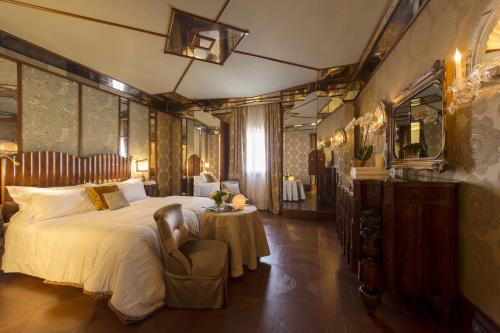 a bedroom with a bed and a table with a chair at Hotel Metropole Venezia in Venice