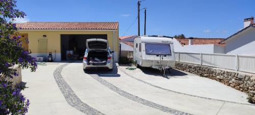 a caravan and a van parked in front of a house at Kyrios Arts Atelier with use of private swimming pool in Carrascal