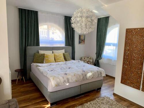 una camera da letto con un letto con tende verdi e un lampadario a braccio di Sokograd Loft a Šipovo