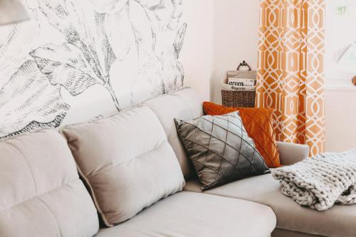 a living room with a white couch with pillows at Hotel Lauterbad in Freudenstadt