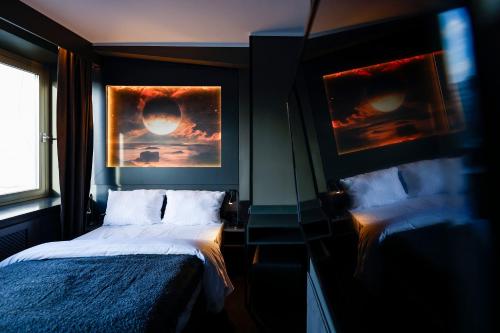 ein Schlafzimmer mit einem Bett und zwei Bildern an der Wand in der Unterkunft Sleephotels Cosmos in Hamburg