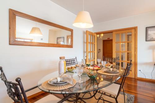 a dining room with a glass table and chairs at Host Wise - Homely Large Flat - Balcony in Guimarães