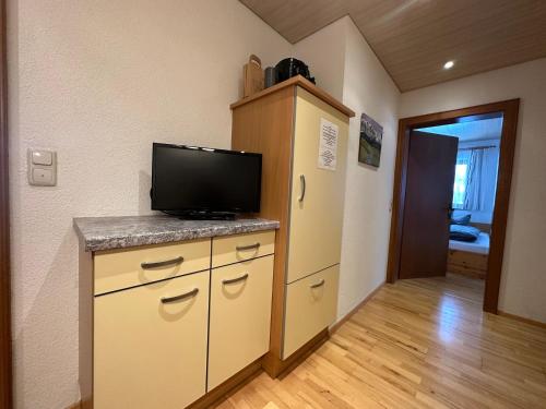 a room with a tv on a counter with a refrigerator at Haus Ausserbach in Gaschurn