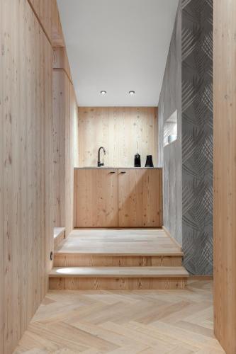 a kitchen with wooden walls and wooden stairs at Hotel Jägerhof in Colfosco