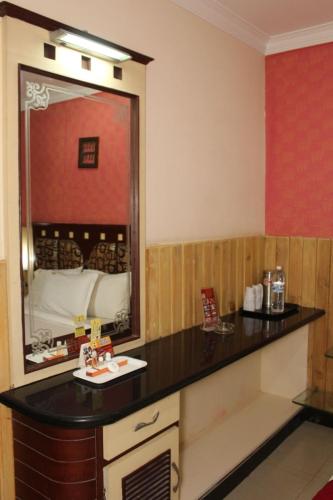 a bathroom with a black counter and a mirror at Hotel Sree Baalaaji Bhavan in Dindigul