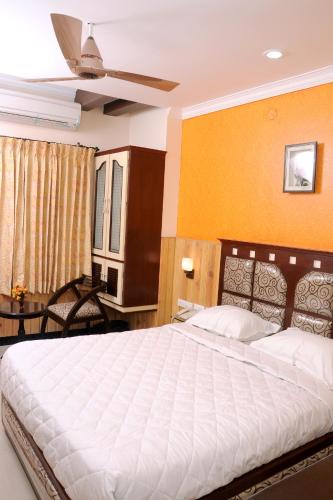 a bedroom with a large white bed in a room at Hotel Sree Baalaaji Bhavan in Dindigul