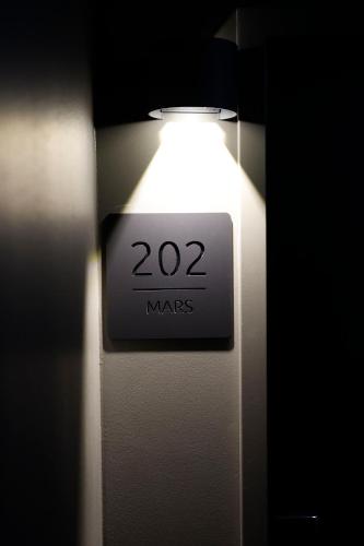 a light on a door with a sign that says mars at Sleephotels Cosmos in Hamburg